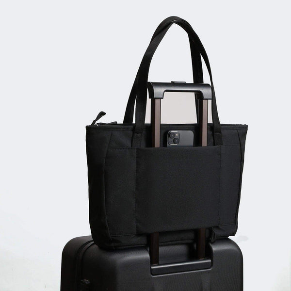 Pander 15L work tote in Black, on a suitcase handle
