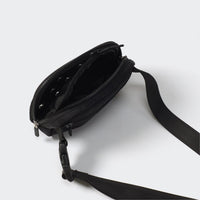 Black dual-zip belt bag open to show divided interior mesh pockets